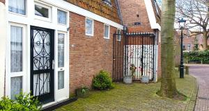 a brick building with a gate and a tree at Studio Nieuwland in Alkmaar