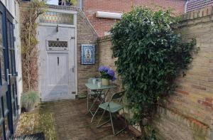 a small table and chairs next to a wall with a door at Studio Nieuwland in Alkmaar +8 photos