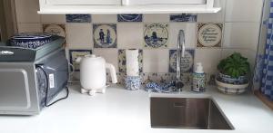 a kitchen counter with blue and white plates on the wall at Studio Nieuwland in Alkmaar