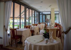 um restaurante com mesas e cadeiras com toalha de mesa branca em Hotel Eden Park em Diano Marina