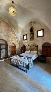 una camera con letto e lampadario a braccio di ROYAL HİSTORY HOTEL & RESORT a Mardin