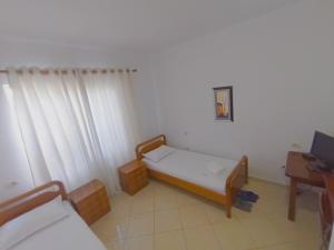 Kleines Zimmer mit einem Bett und einem Schreibtisch. in der Unterkunft Vila 57 HOTEL in Tirana