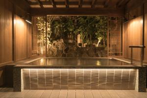 Atami Onsen Hotel Yume Iroha في أتامي: حوض استحمام ساخن في وسط الغرفة