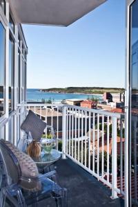 uma varanda com uma cadeira, uma mesa e o oceano em Seaside Serenity - Stunning Beach Views in Maroubra em Sidney