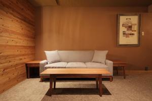 UNWIND Hotel & Bar Sapporo في سابورو: غرفة معيشة مع أريكة وطاولة قهوة