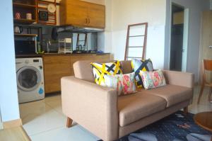 a living room with a couch with pillows on it at Munchkin Seafront Residence bossku in Kuantan