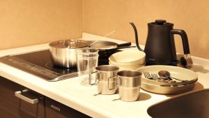 une cuisinière avec des casseroles et des poêles sur un comptoir dans l'établissement UNWIND Hotel & Bar Sapporo, à Sapporo