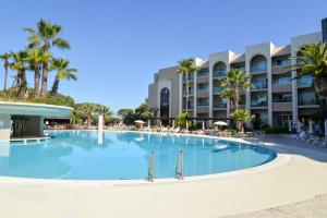 une grande piscine en face d'un hôtel dans l'établissement Falésia Hotel - Adults Only, à Albufeira