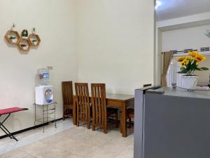 uma cozinha com uma mesa e cadeiras e um micro-ondas em Nazifa Homestay em Batu