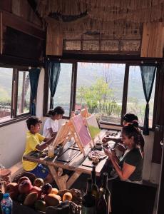 un grupo de personas sentadas alrededor de una mesa de madera en Pavi garden, en Sa Pa