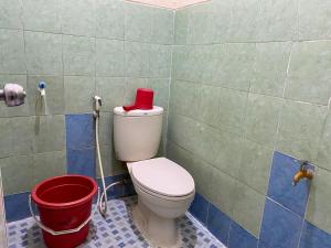 uma casa de banho com um WC com uma caixa vermelha em Nazifa Homestay em Batu