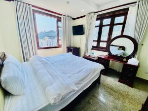 1 dormitorio con 1 cama grande y espejo en WHITE HOUSE - Nhà khách Báo nhân dân en Tam Ðảo