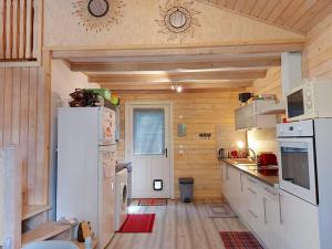 a kitchen with white appliances and a white refrigerator at Chalet au milieu de la forêt avec lac à proximité in Layrac +24 photos