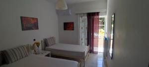 a white room with two beds and a window at Chania City Apartments in Chania