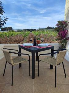 a black table with two chairs and a table with wine glasses at Le Anfore del Salento Bed and Breakfast in Marina di Lizzano