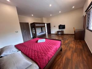 1 dormitorio con 1 cama con edredón rojo en Hari's Haven en Kodaikānāl