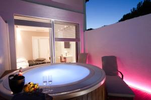 a bath tub in a room with pink lighting at Villaggio La Pescaccia in San Clemente