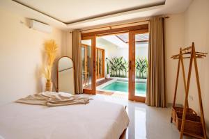 1 dormitorio con cama y piscina en Best Place by walking, Beach, Brand NEW Villa, Canggu en Kerobokan