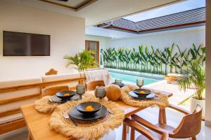 a living room with a table and a pool at Best Place by walking, Beach, Brand NEW Villa, Canggu in Kerobokan