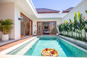 a swimming pool in a villa with a house at Balibay 2 - Best Place by walking, Beach, Brand NEW Villa, Canggu in Kerobokan +2 photos