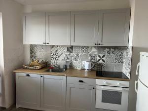 a kitchen with white cabinets and a counter top at Art Apartment Mali Losinj in Mali Lošinj