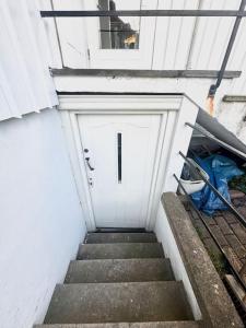 a staircase leading to a white garage with a door at Superhomes 1 BR in Gothenburg