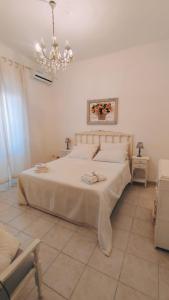 una camera con letto bianco e lampadario pendente di YSOR CASA VACANZE a Casalabate
