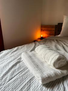 Una cama blanca con dos toallas. en Göcsej Kapuja Vendégház 