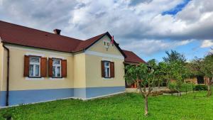 una pequeña casa amarilla con techo rojo en Göcsej Kapuja Vendégház 