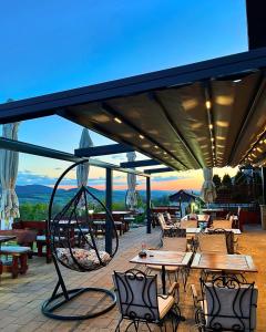 a patio with tables and chairs with a view at Vila Breg Zlatibor in Zlatibor