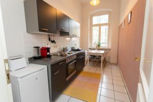 a kitchen with black appliances and a table with a window at FULL HOUSE Premium Apartments - Halle Paulusviertel in Halle an der Saale