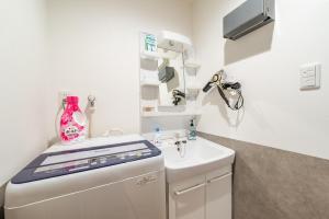 a small kitchen with a sink and a washing machine at 梅田駅まで電車で5分 コンビニ居酒屋1分 最寄駅3分 長期歓迎 建物2階 in Osaka