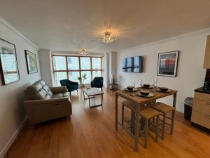 a living room with a table and a couch at Millgrove House Apartments in Eastbourne