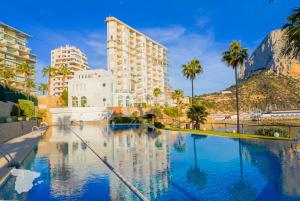 una gran piscina con palmeras y edificios en Paradero de Ifach Sotavento CostaBlancaDreams, en Calpe