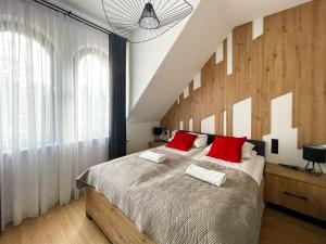 una camera da letto con un grande letto con cuscini rossi di VisitZakopane - Radowid Loft Spa Apartment a Zakopane