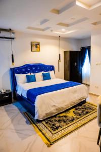 sypialnia z dużym niebieskim łóżkiem w pokoju w obiekcie El Elyon Hotel and Suites w mieście Lagos
