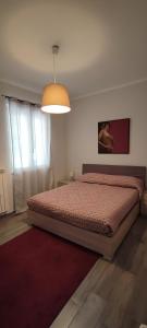 a bedroom with a bed with a red comforter at Casa vacanza Agrippina in Bacoli
