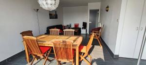 ein Esszimmer mit einem Holztisch und Stühlen in der Unterkunft La Nantaise de la mer in Saint-Hilaire-de-Riez