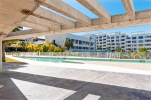 una piscina con un edificio de fondo en Stunning flat with pool and padel in Wellingtonia M4, en Estepona
