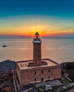 um farol na costa do oceano ao pôr do sol em Martino10 em Carloforte