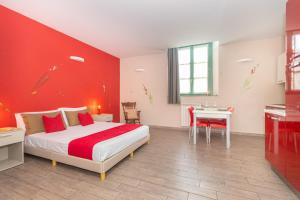 ein rotes Schlafzimmer mit einem Bett und einem Tisch in der Unterkunft Housing Giulia in Turin