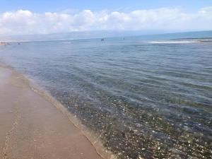 a beach with the sand and the water at Ippocampo alba e tramonto in Ippocampo