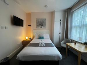Un dormitorio con una cama con un osito de peluche. en United Lodge Hotel, en Londres