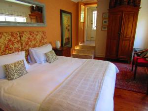 a bedroom with a large white bed with pillows at Rosedene Guest House in Cape Town