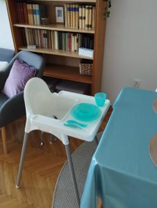 uma cadeira branca alta e uma mesa num quarto em Greenview Apartment em Budapeste