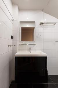 a white bathroom with a sink and a mirror at Midtown Hotel Twin Studio in Amsterdam