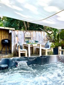a plunge pool with a table and chairs in a backyard at The Lodge@Tyddyn Ucha in Caernarfon