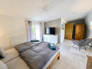 1 dormitorio con 1 cama, 1 silla y TV en Haus mit 110qm und Garten 150m zum Wasser en Stralsund