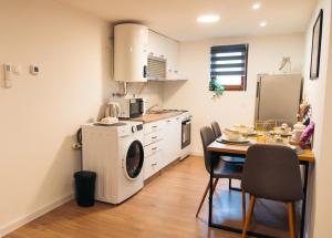a kitchen with a washing machine and a table with chairs at Merak in Donji Miholjac