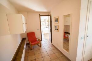 a living room with a red chair and a table at Al Beo in Finale Ligure
